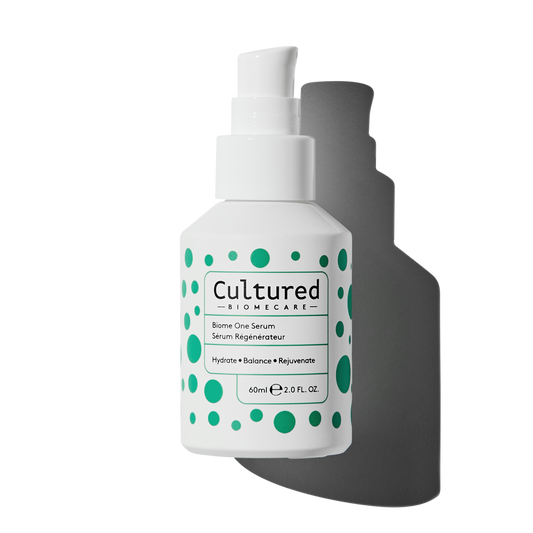 The white Biome One Serum bottle has a pump and features green spots in an assortment of sizes.