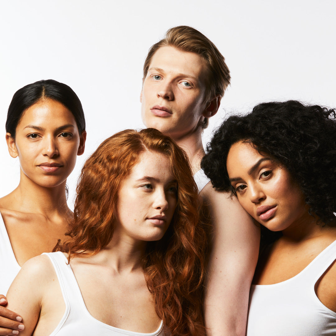 A shoulders up image of four models with clear skin.