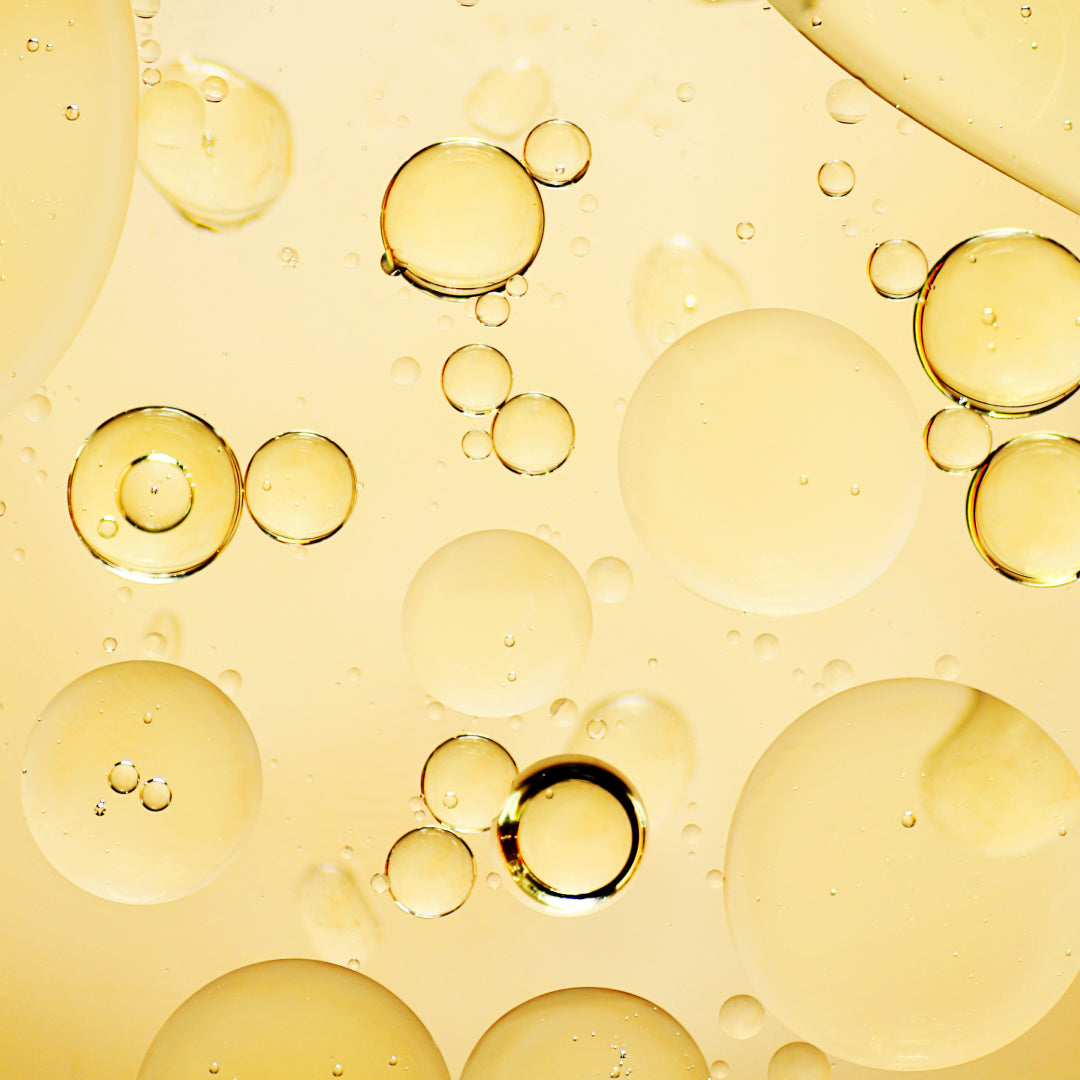 Close up of a translucent yellow liquid with bubbles.
