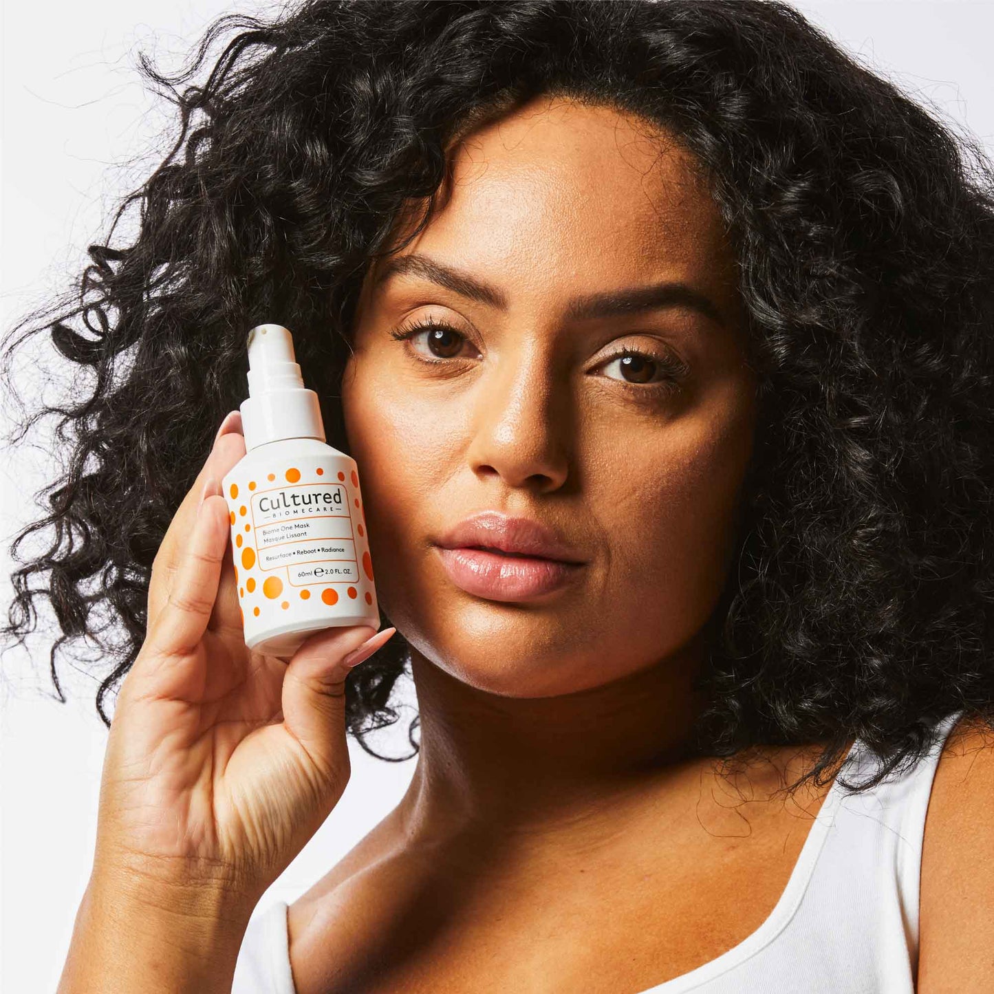 A women holds a bottle of the face mask facing the camera